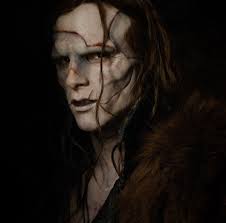 The Creature in Guillermo del Toro's Frankenstein. He is a handsome man but unnaturally pale, with numerous scars across an unhappy face and long stringy dark hair.